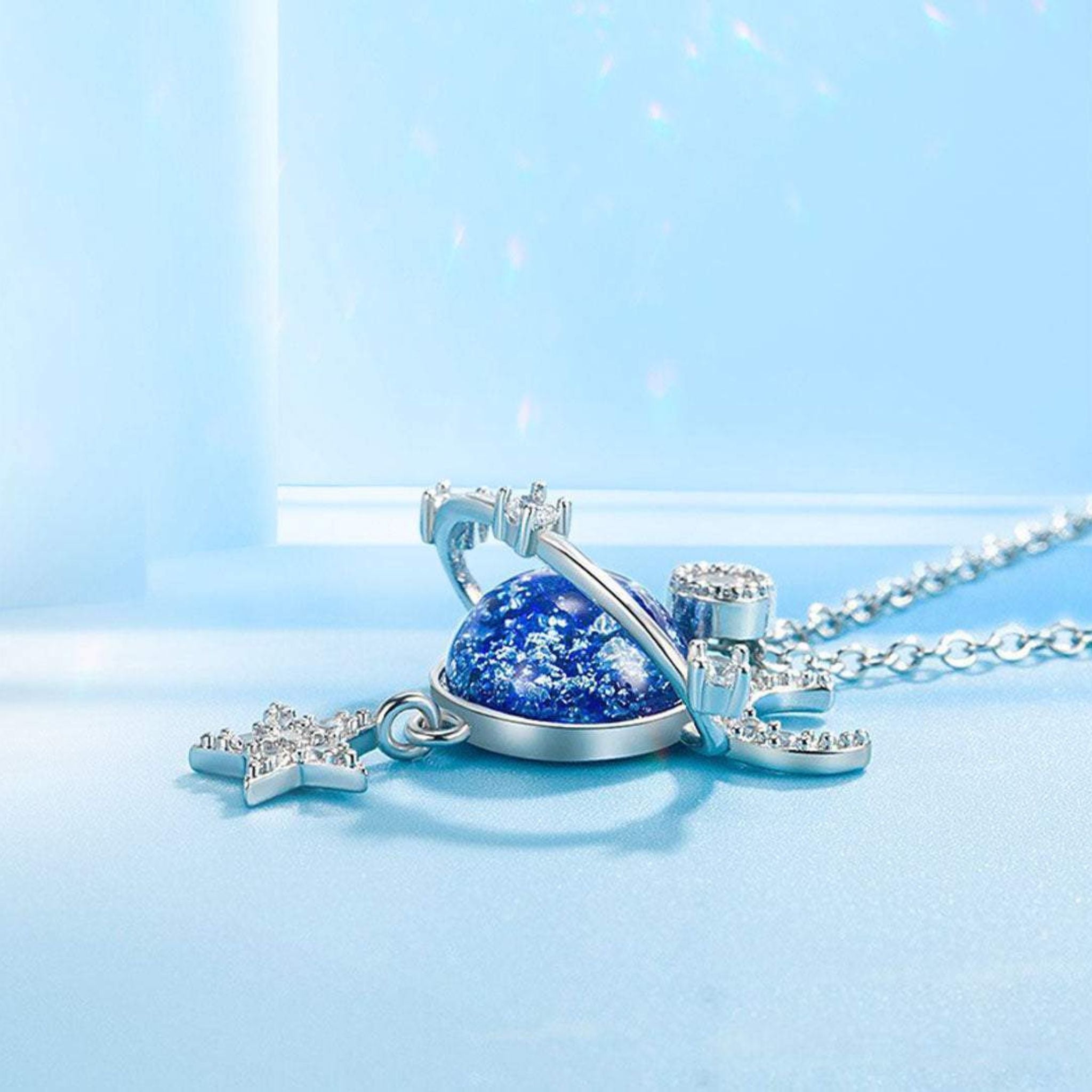 Collana con design cosmico, pietra centrale blu e stella pendente, ideale come regalo speciale.

