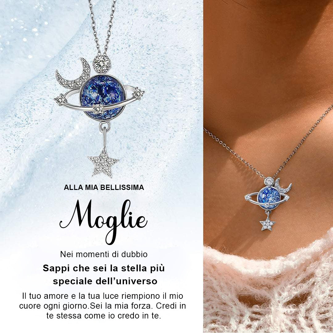 Collana con ciondolo a tema planetario, con pietra blu, luna e stella pendente, indossata su collo femminile.

